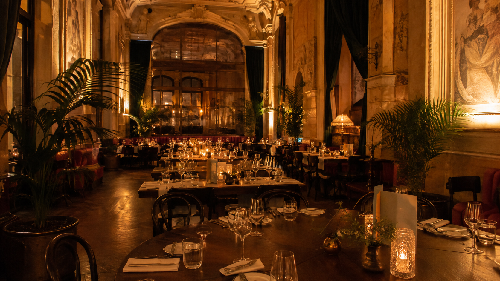 Meleg fényű budapesti grand café étterem vacsorára megterített asztalokkal